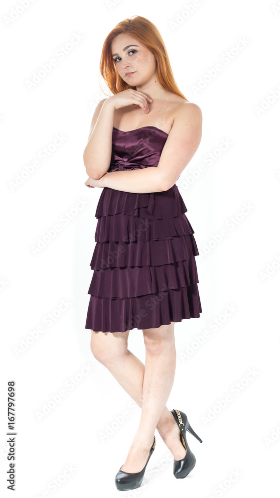 Full body portrait of young girl. Redheaded girl wearing dark purple strapless dress.