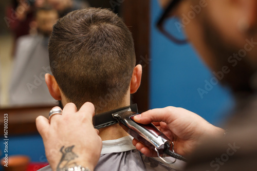 Man getting haircut by hairstylist at barbershop © Prostock-studio