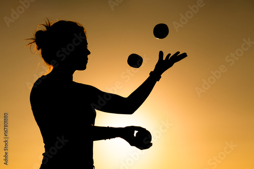 Silhouette of a Woman Juggling with Balls at Sunset