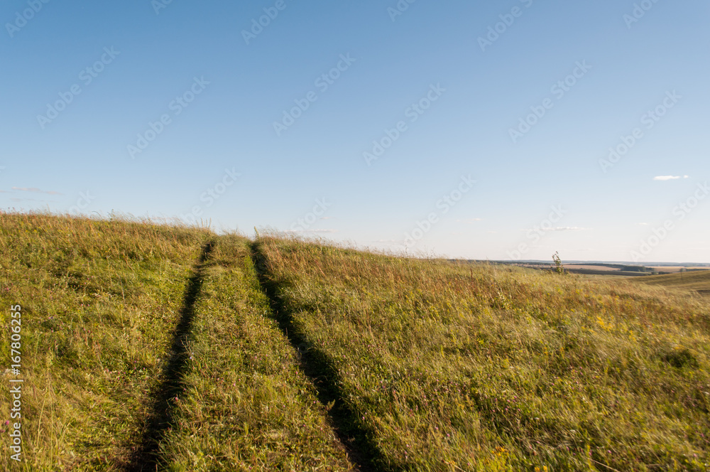 Summer landscape with green grass, road and clouds, concept: road to dream Summer landscape with green grass, road and clouds, concept: road to dream