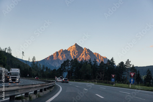 Highway early morning with cars and mountains in the background