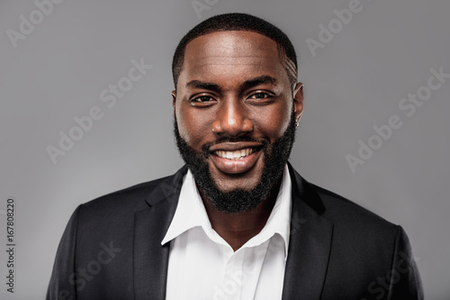 Cheerful successful young  African American man studio portrait in full suit