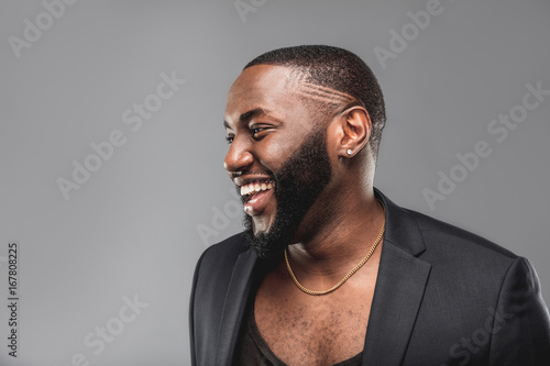 Cheerful successful young  African American man studio portrait in full suit