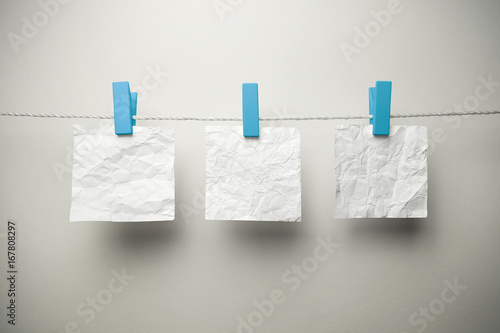 Crumpled sheets of paper hanging with clothespins