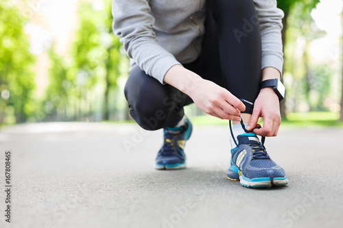 Woman tying shoes laces before running