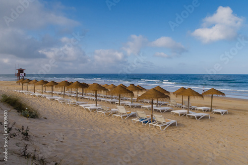 Straw umbrellas on the beach of Barrosa de Sancti Petri, Chiclana, Cadiz, Spain