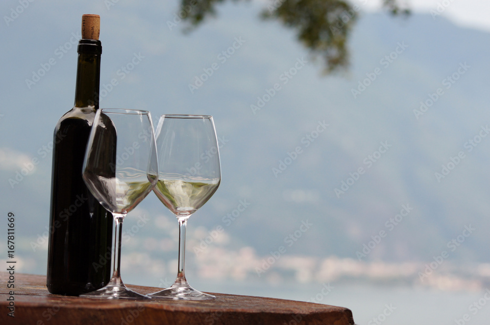 Bouteille de vin et deux verres vides sur paysage