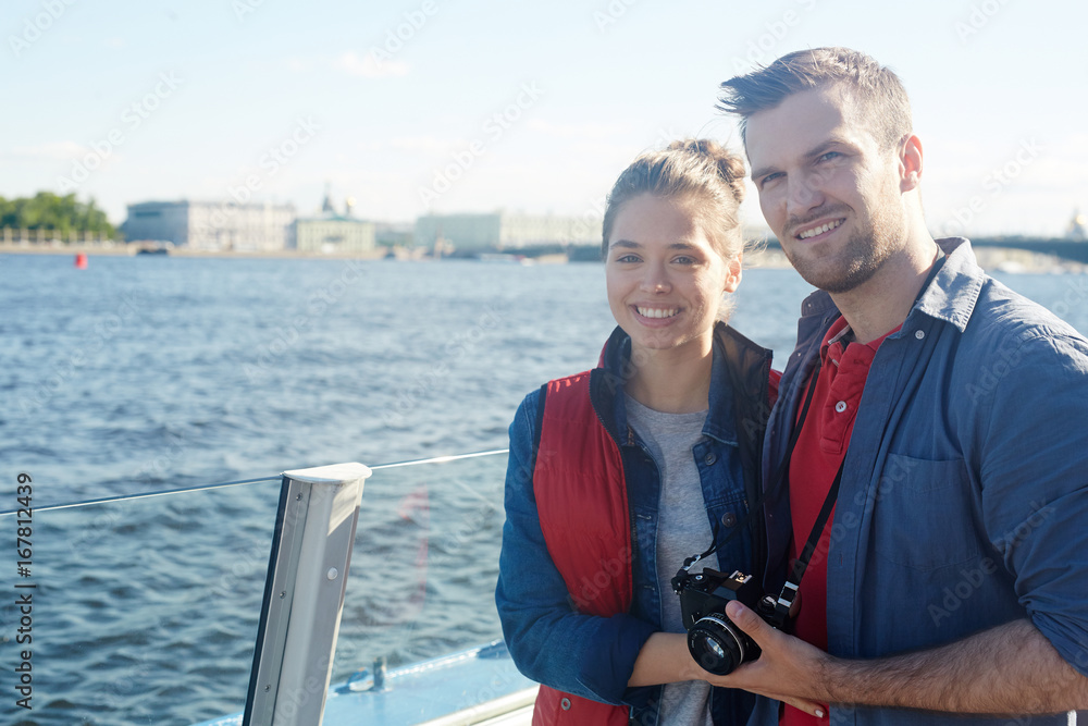 Young tourists with photocamera enjoying travel by water Young tourists with photocamera enjoying travel by water