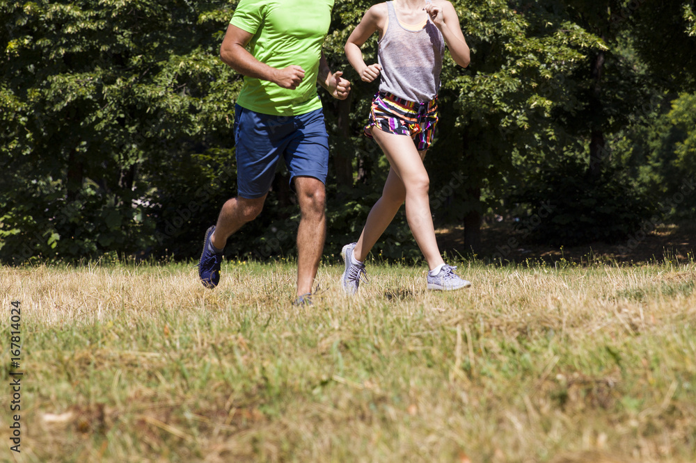 Young couple running in the park on a sunny day