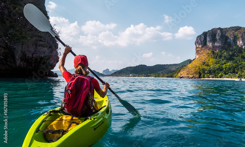Woman paddles kayak in the tropical sea
