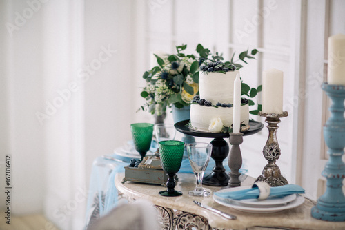 beautiful decorate table with candles  vase with flowers and wedding cake on the table in studio