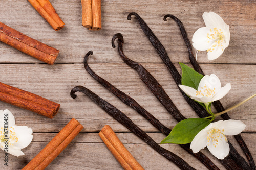 Vanilla sticks and cinnamon with flower and leaf on a old wooden background