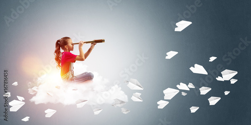 Concept of careless happy childhood with girl looking in spyglass
