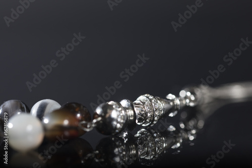 Close-up rosary inlaid with crystals on a dark background © Wasim Alnahlawi