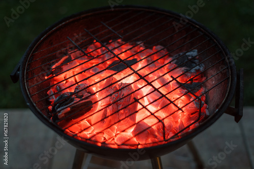 Burning coals and sparks coming out of the barbecue. BBQ brazier with sparks.