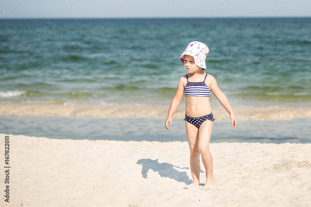Little cute blonde girl running along the beach Little cute blonde girl running along the beach