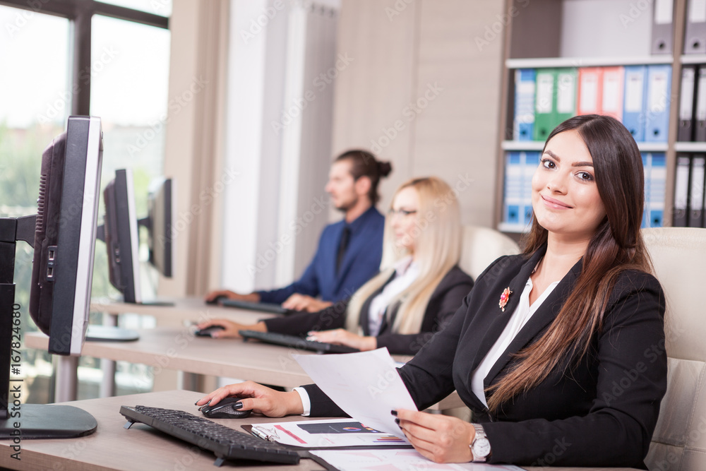 Business person working in office next to colleagues Business person working in office next to colleagues