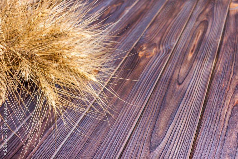 Fototapeta premium ears of wheat on wooden background Harvest concept