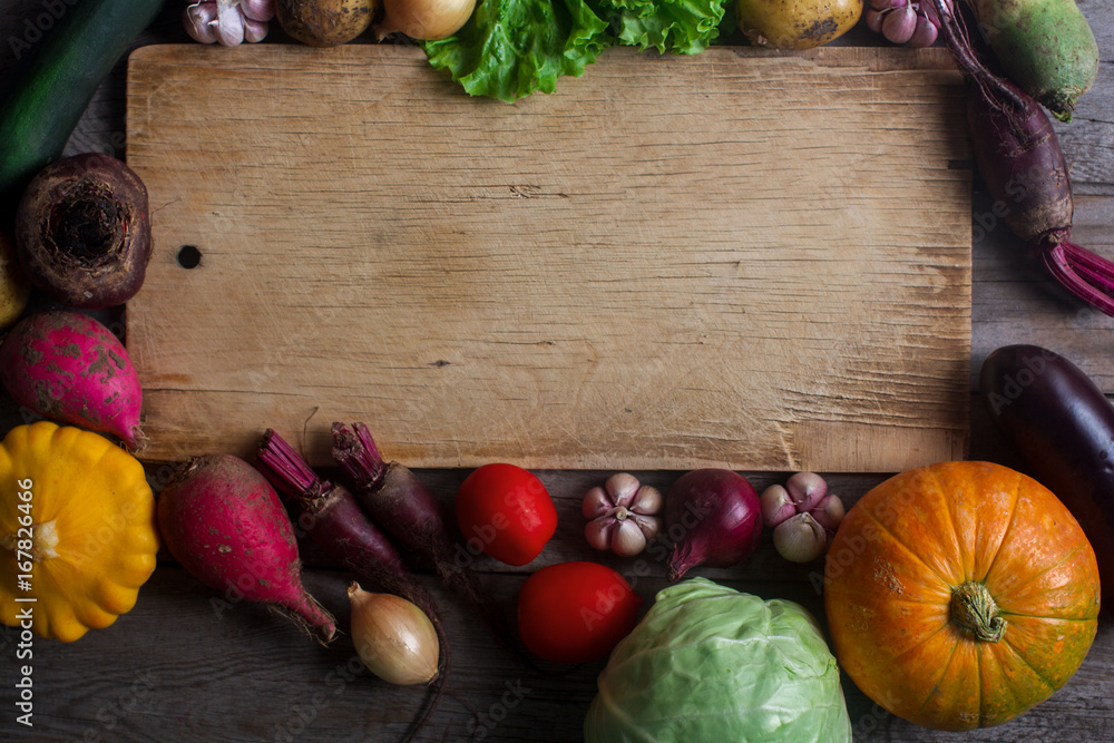 raw organic fresh vegetables and wooden board in rustic style. Harvest time, colorful vegetables, healthy lifestyle raw organic fresh vegetables and wooden board in rustic style. Harvest time, colorful vegetables, healthy lifestyle