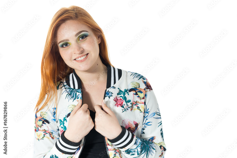 Beautiful girl smiles and looks at the camera. Redheaded girl wearing colorful jacket. Summer..