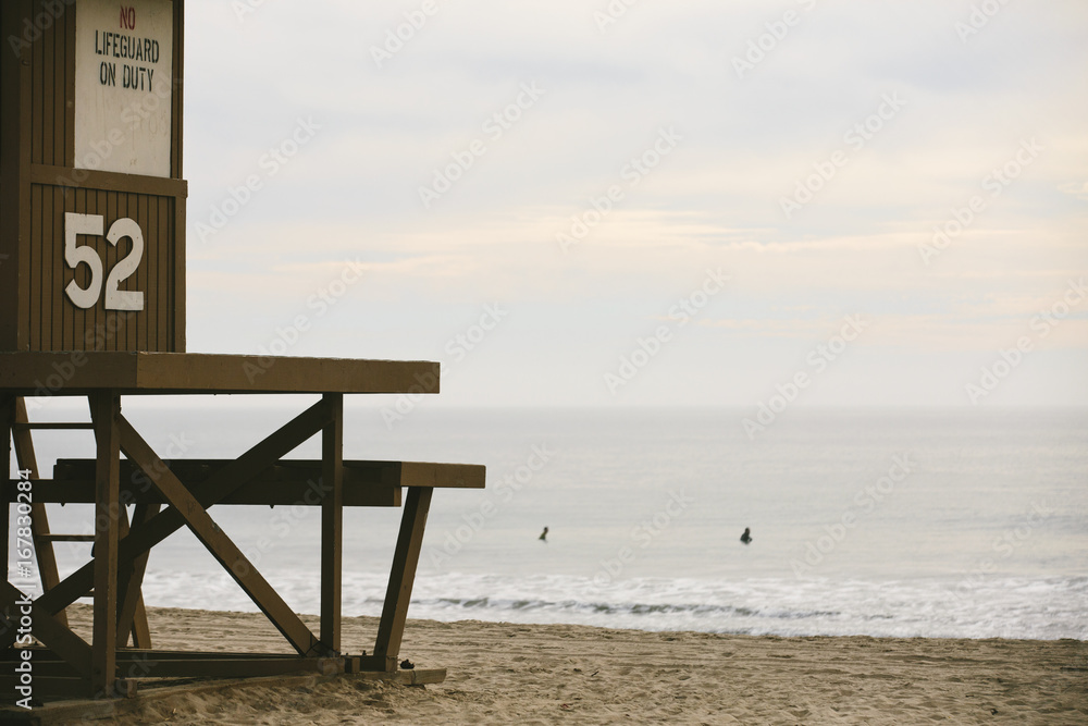 Lifeguard tower with ocean and surfers in the water Lifeguard tower with ocean and surfers in the water