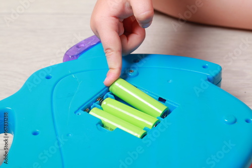 Wallpaper Mural hand the child put the batteries in the red toy Torontodigital.ca