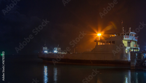 The fishing boat is on the docks at night