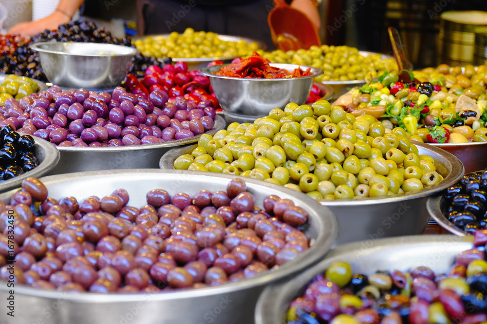 Different fresh olives in bowls at market