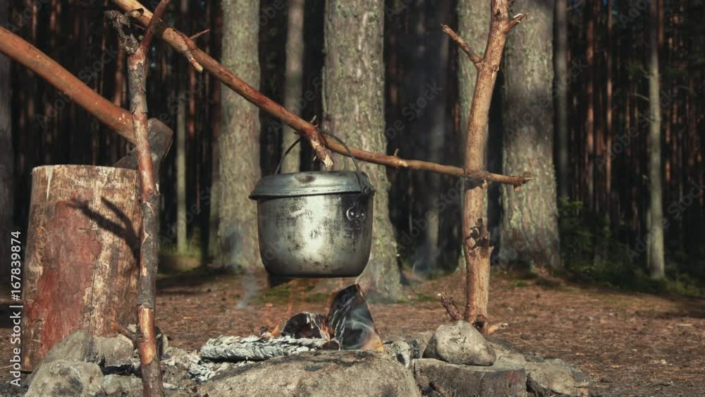 Kettle over campfire on sunny afternoon Kettle over campfire on sunny afternoon