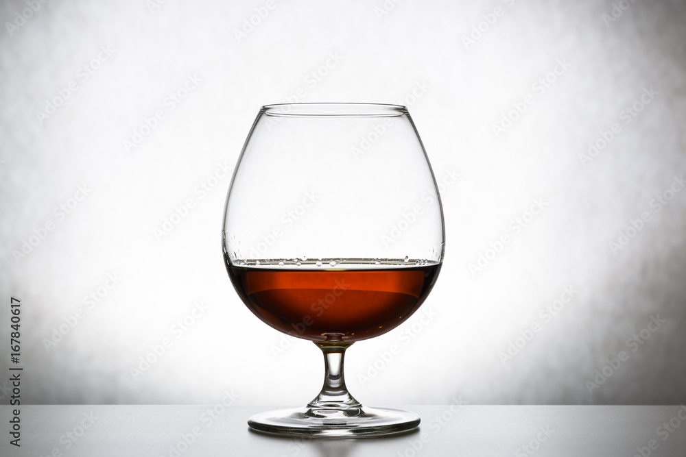 Glass with cognac on white background isolated. Front view. Close up shot. High resolution Glass with cognac on white background isolated. Front view. Close up shot. High resolution