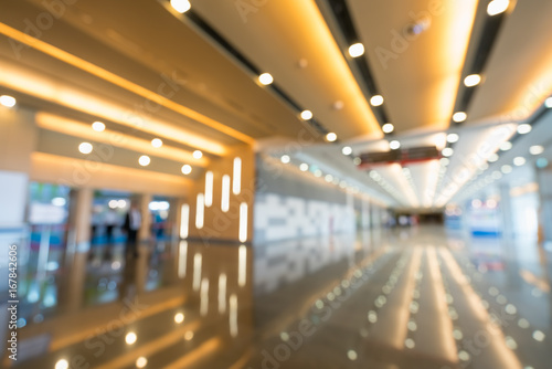 Blurred, defocused bokeh background of grand hallway, exhibition hall, or trade show event. International convention center, modern interior architecture, or commercial tradeshow organizer concept