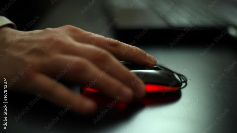 Human hand on computer mouse. Laptop on desk. Human hand on computer mouse. Laptop on desk.