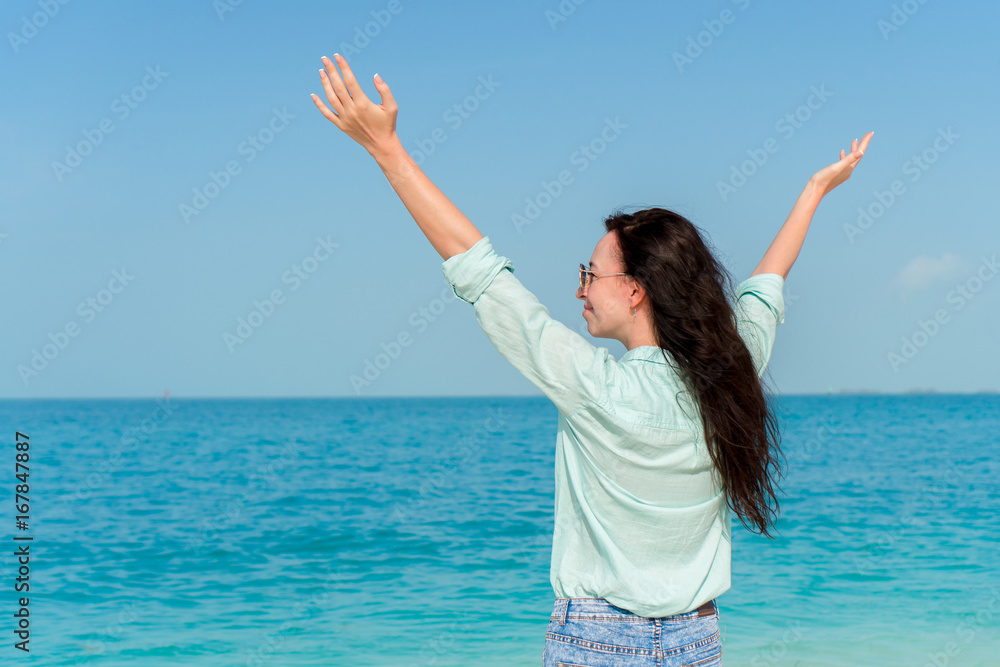 Young beautiful woman on tropical seashore. Back view of young girl background the sea Young beautiful woman on tropical seashore. Back view of young girl background the sea
