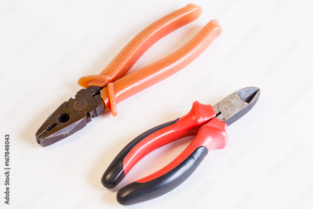 A couple of tools for electro installation. Cutters and pliers on a light background. A couple of hand tools. A couple of tools for electro installation. Cutters and pliers on a light background. A couple of hand tools.