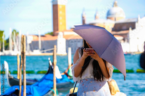 Venice, Italy - July, 28, 2017: girl with an umbrella near the Channel in Venice, Italy photo