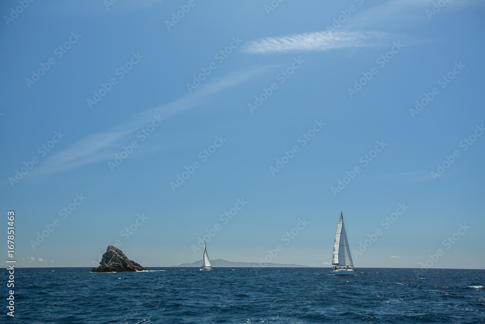 Sailing ship yachts with white sails in the open Sea.