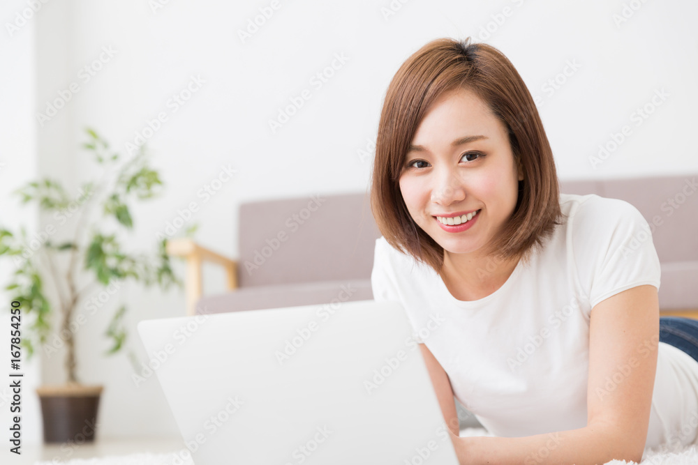 部屋でパソコンを見る女性 部屋でパソコンを見る女性