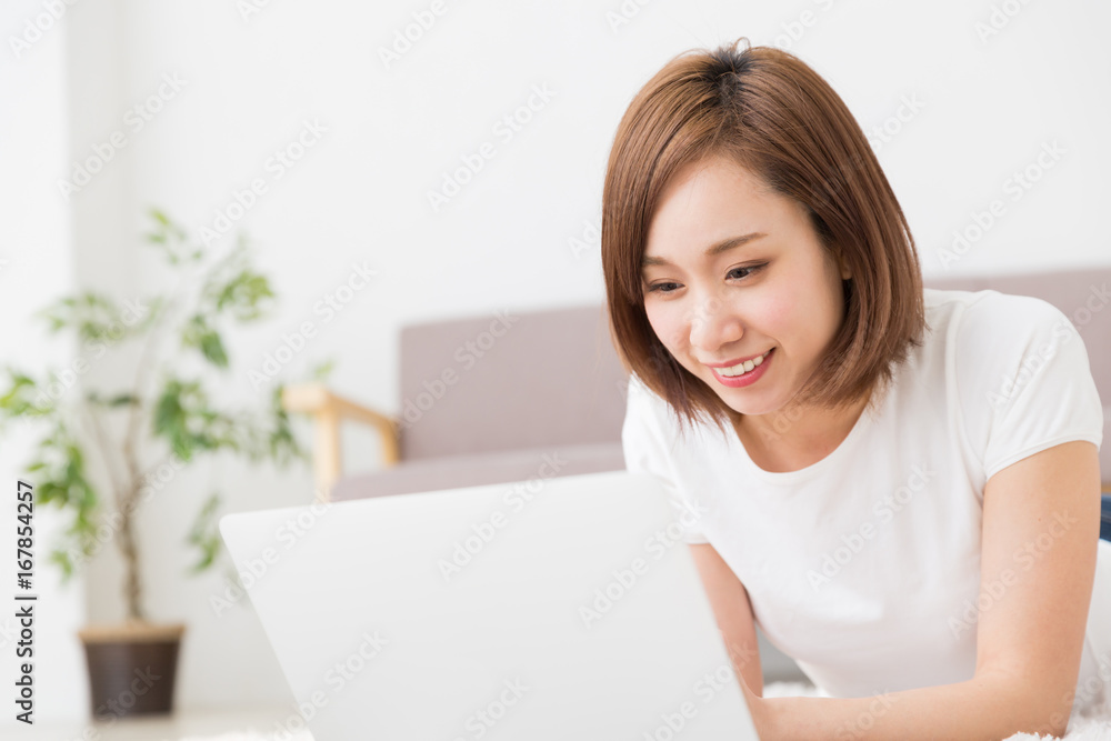 部屋でパソコンを見る女性 部屋でパソコンを見る女性