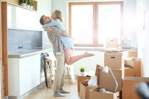 Portrait of young couple moving in new home. Young couple