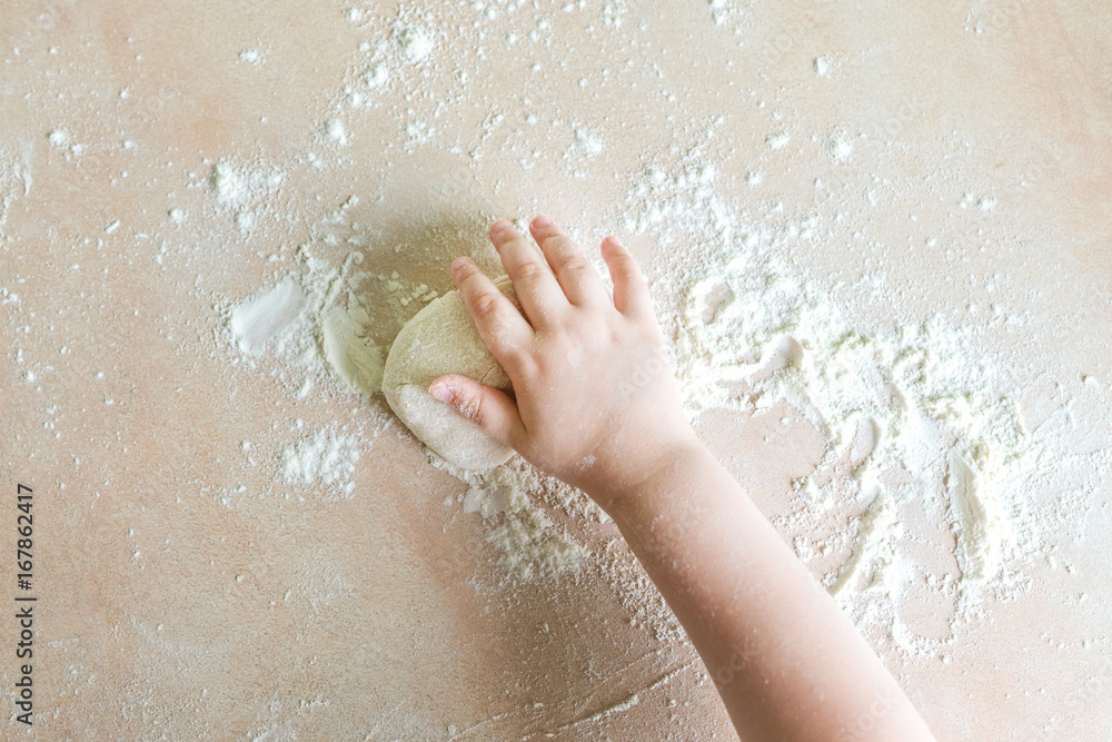 Children's hands make dough
