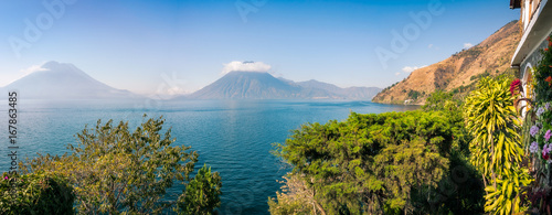 Scenic Panoramic View of Lake Atitlan and Volcanoes San Pedro and Toliman in Guatemala, from a charming resort with luxuriant tropical vegetation. photo