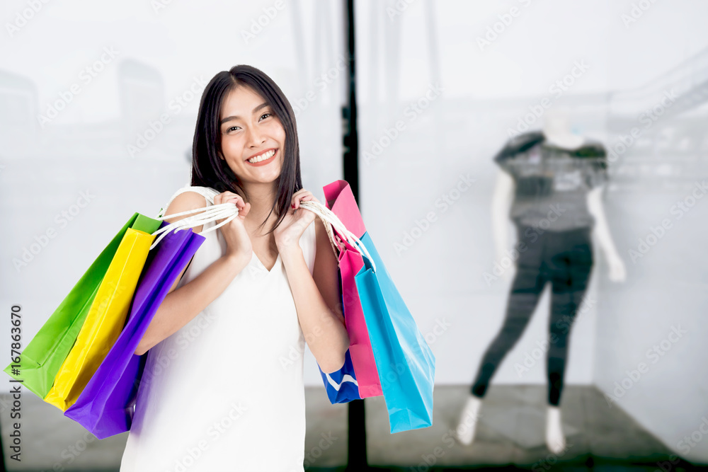 Woman holding shopping bag walking on the street Woman holding shopping bag walking on the street