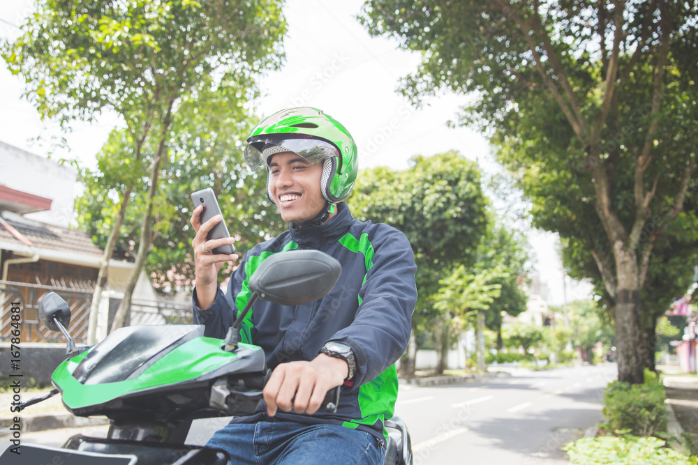 motorcycle taxi driver taking order via mobile phone online app