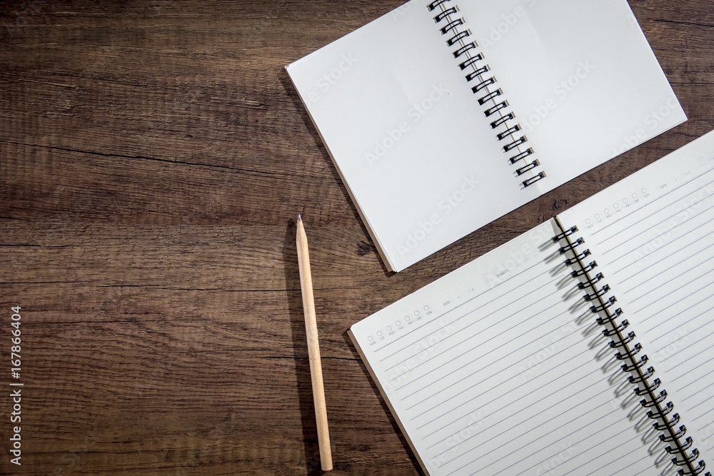 Top view notebook paper on wooden background. Concept for business and education.