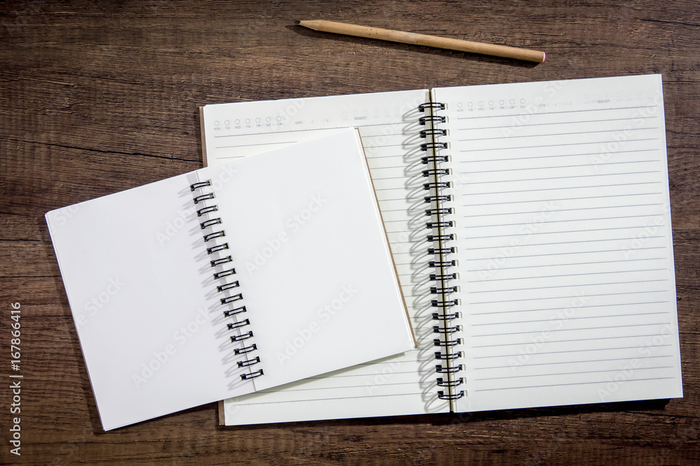 Top view notebook paper on wooden background. Concept for business and education. Top view notebook paper on wooden background. Concept for business and education.