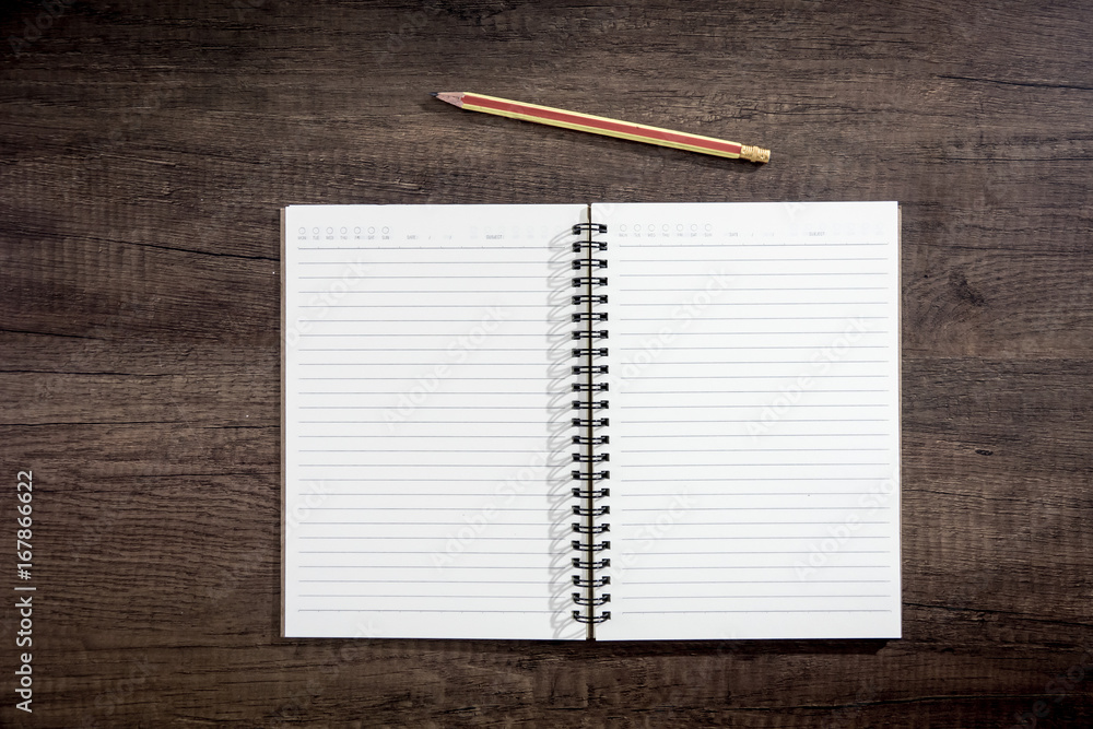 Top view notebook paper on wooden background. Concept for business and education. Top view notebook paper on wooden background. Concept for business and education.