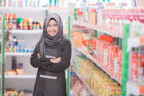 female muslim shopkeeper working at supermarket