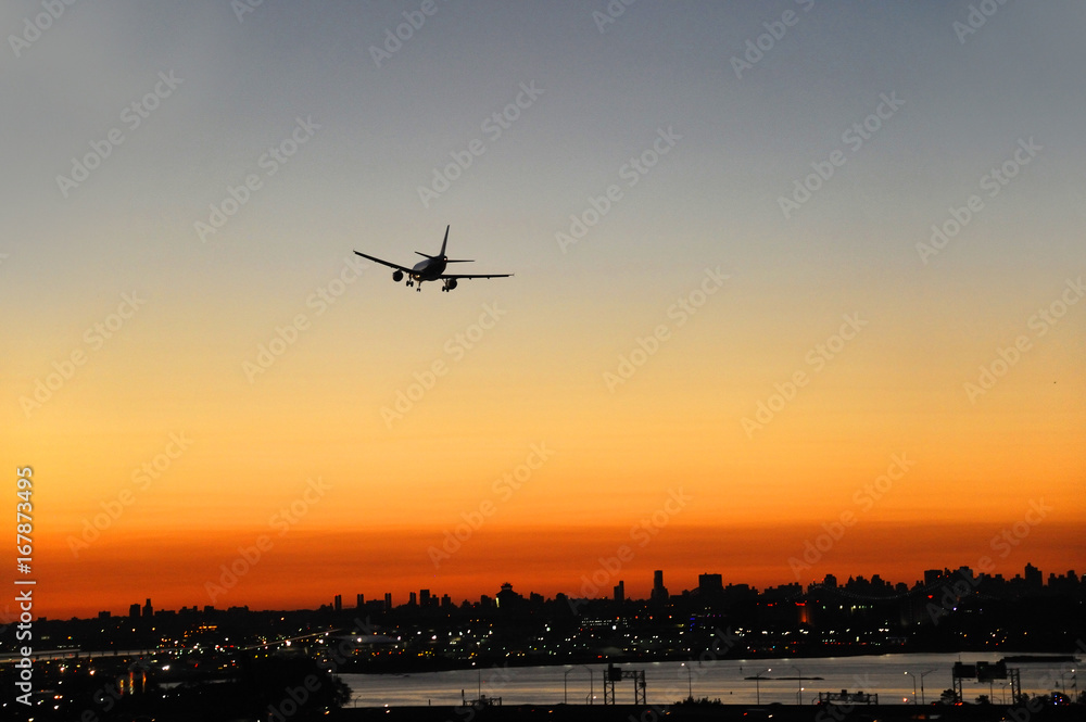 airplane on the colorful sunset sky in New York