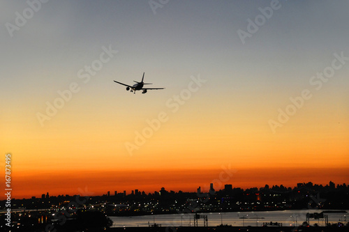 airplane on the colorful sunset sky in New York