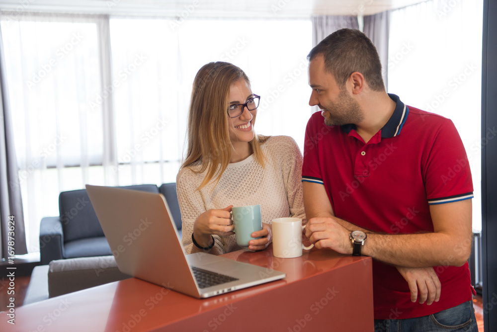 couple drinking coffee and using laptop at home couple drinking coffee and using laptop at home